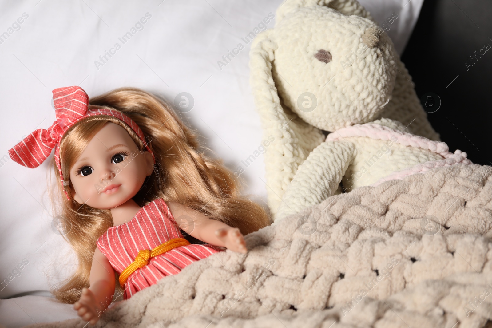 Photo of Beautiful doll and toy bunny in bed