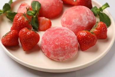 Photo of Delicious mochi, strawberries and mint on light table, closeup