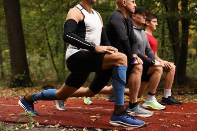 Photo of Group of people stretching in park. Healthy lifestyle