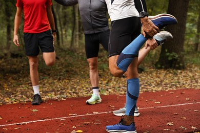 Photo of Group of people stretching in park, closeup