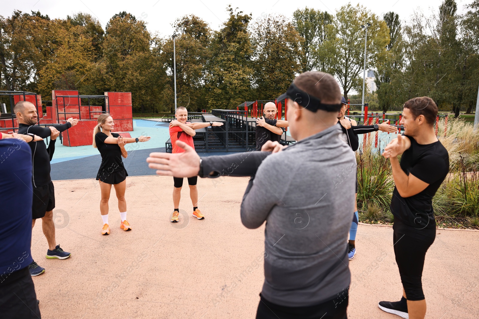 Photo of Group of people exercising and stretching outdoors