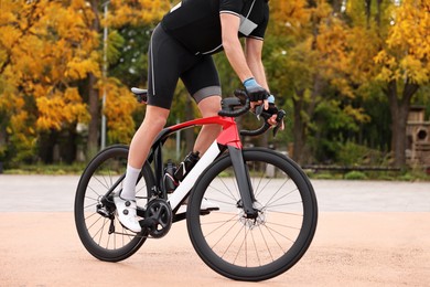 Photo of Athletic man with helmet riding bicycle outdoors, closeup