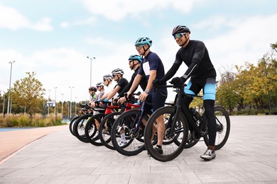 Photo of Group of athletic people with bicycles outdoors