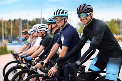 Photo of Group of athletic people with bicycles outdoors