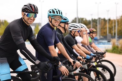 Photo of Group of athletic people with bicycles outdoors