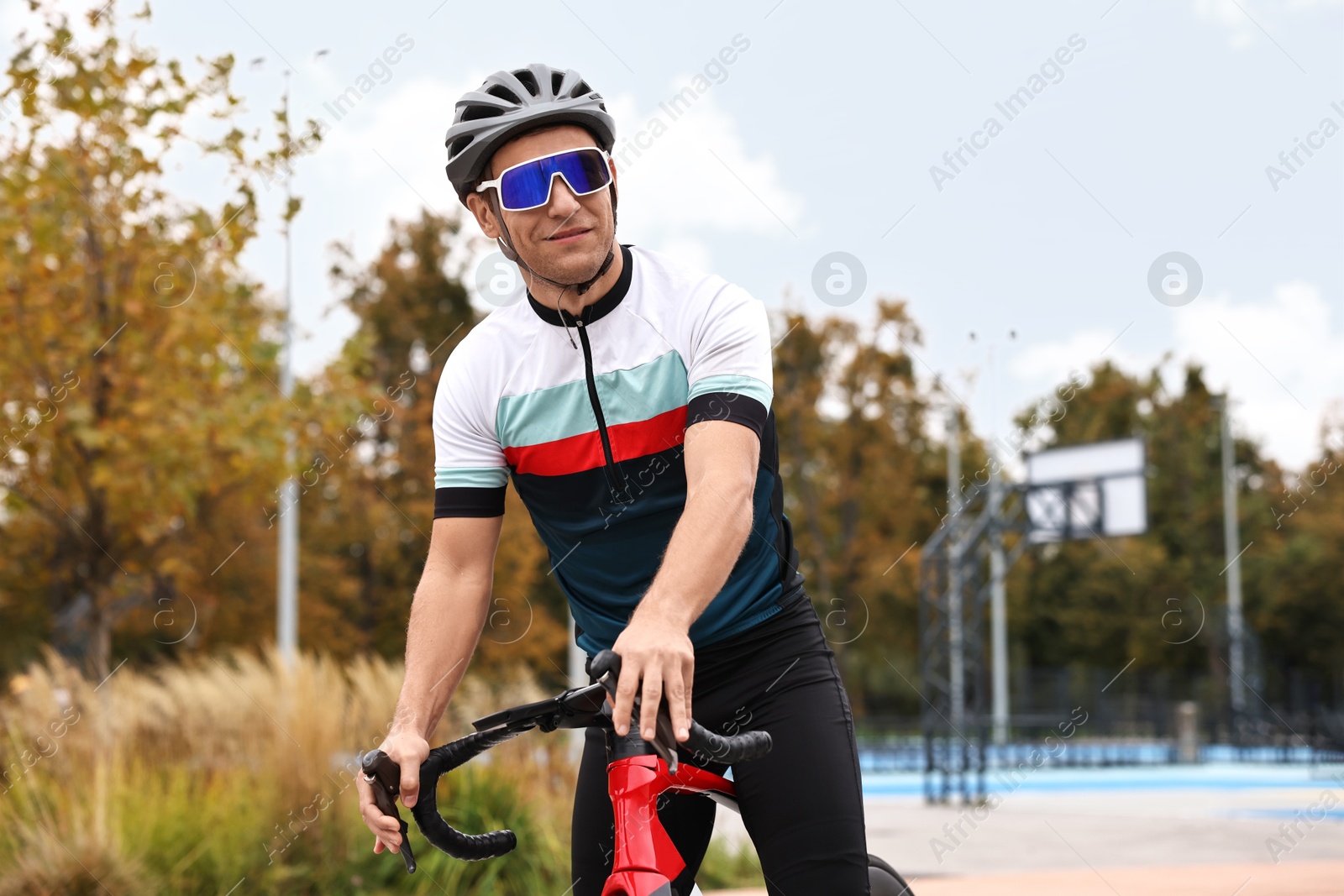 Photo of Athletic man with helmet and bicycle outdoors