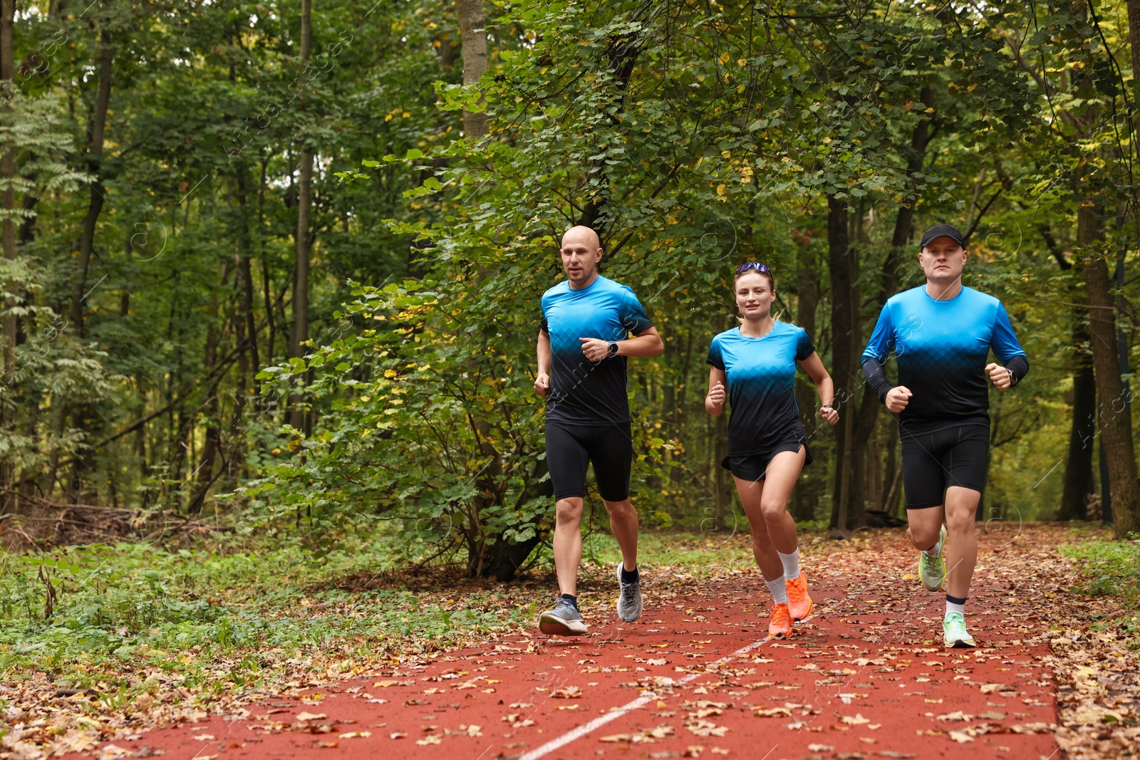 Photo of Group of athletic people running in park. Space for text