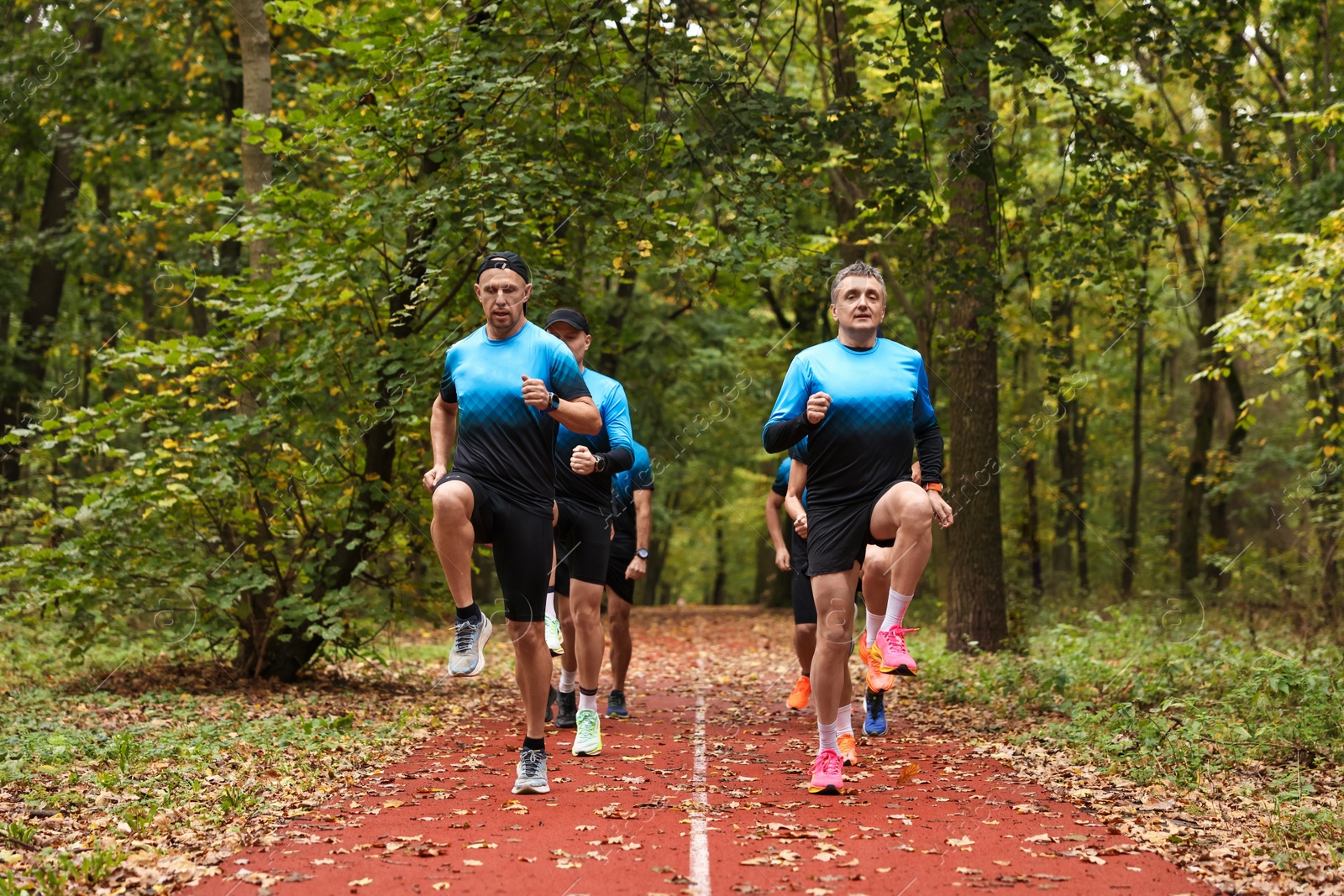 Photo of Group of athletic people running in park