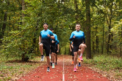 Photo of Group of athletic people running in park