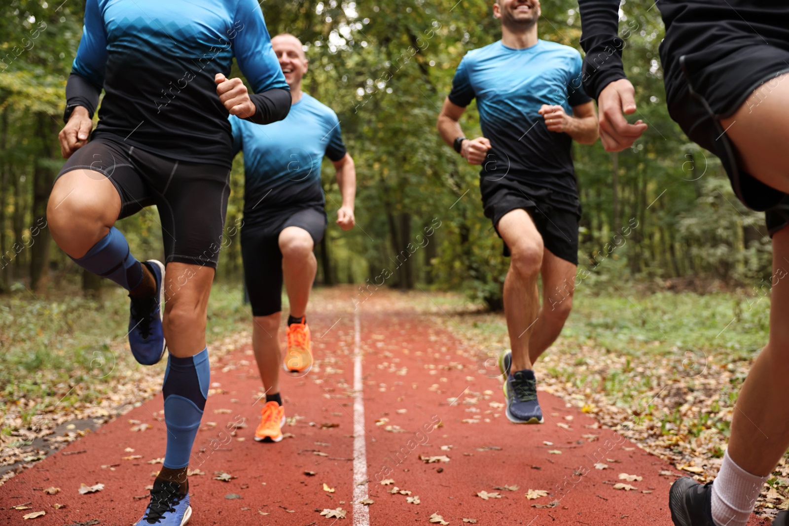 Photo of Group of athletic people running in park