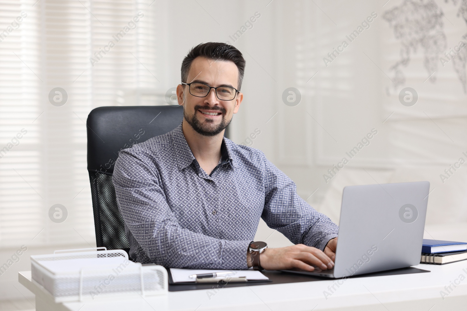 Photo of Portrait of smiling banker at table in office