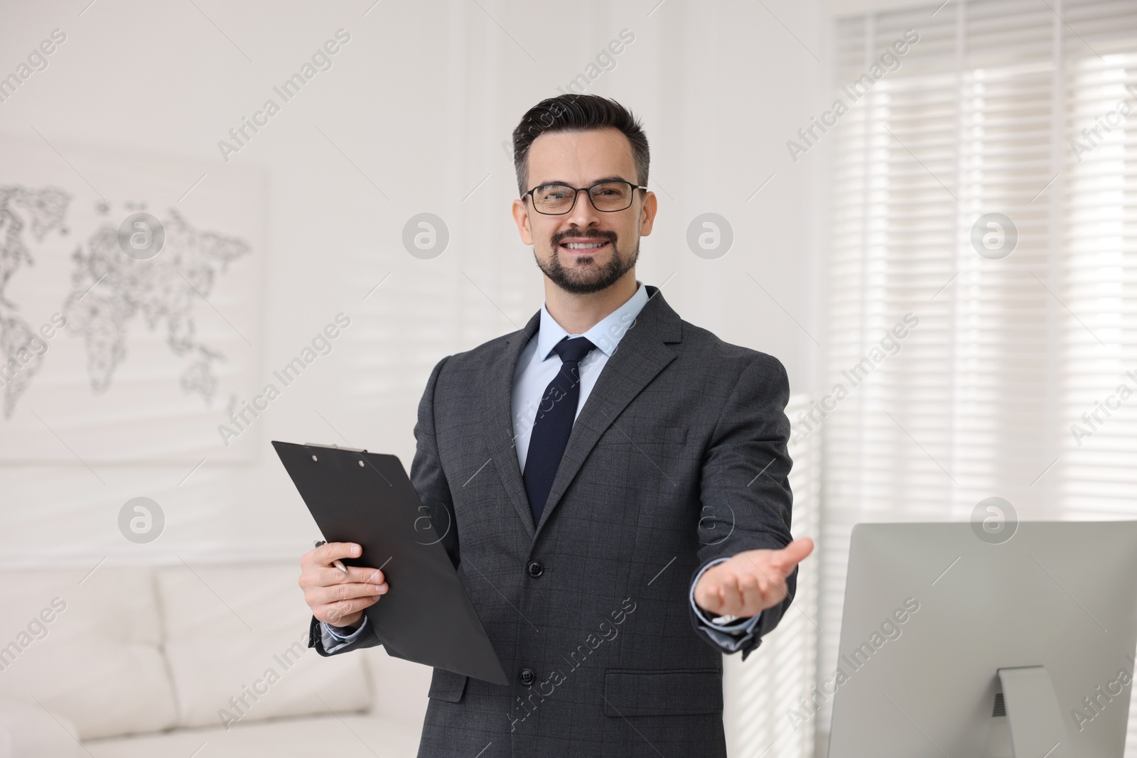 Photo of Smiling banker with clipboard holding something in office