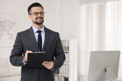 Photo of Smiling banker with clipboard making notes in office. Space for text