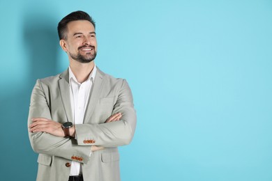 Photo of Portrait of smiling banker with crossed arms on light blue background. Space for text