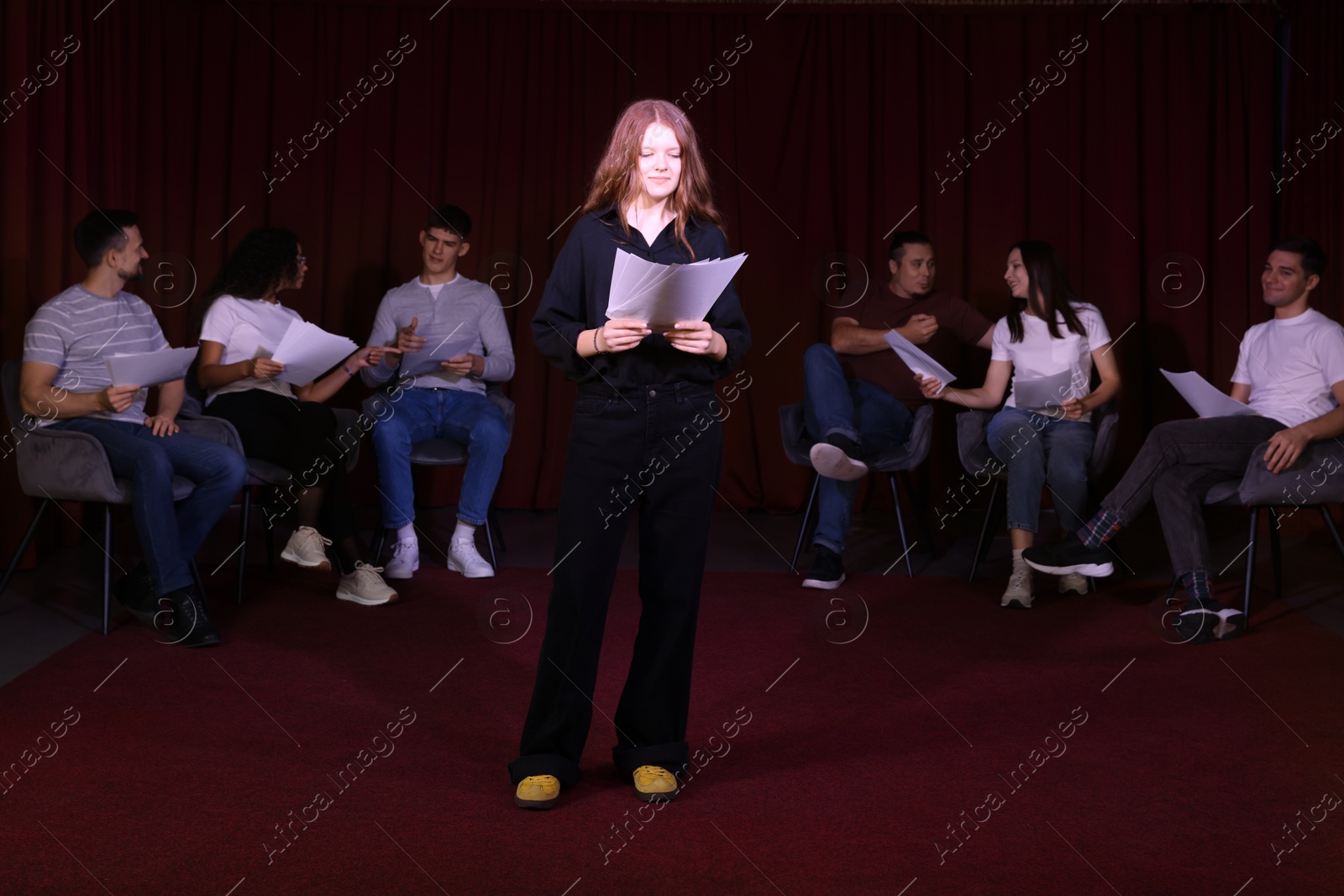 Photo of Professional actors reading their scripts during rehearsal in theatre