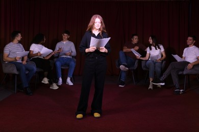 Photo of Professional actors reading their scripts during rehearsal in theatre