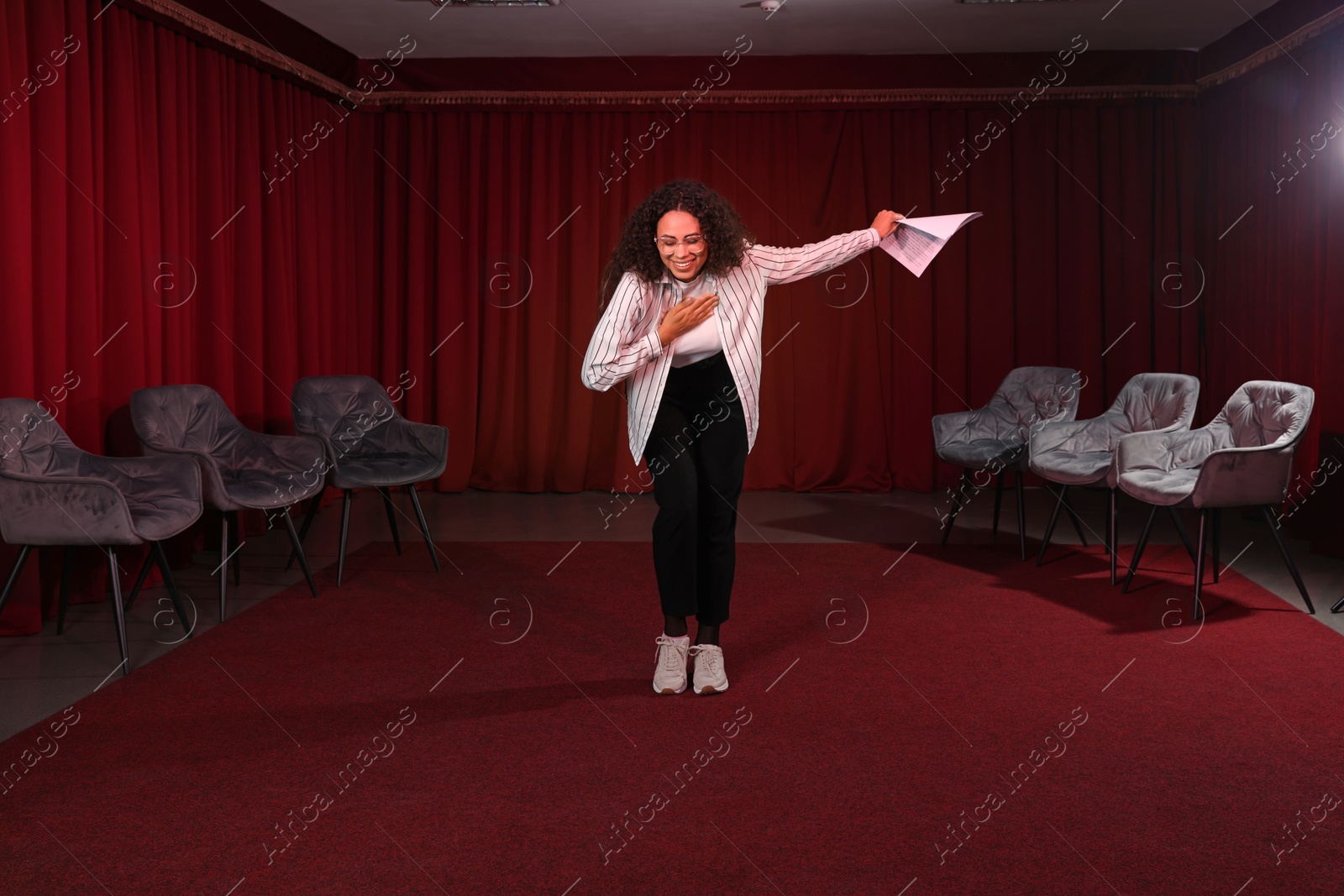 Photo of Professional actress bowing on stage in theatre