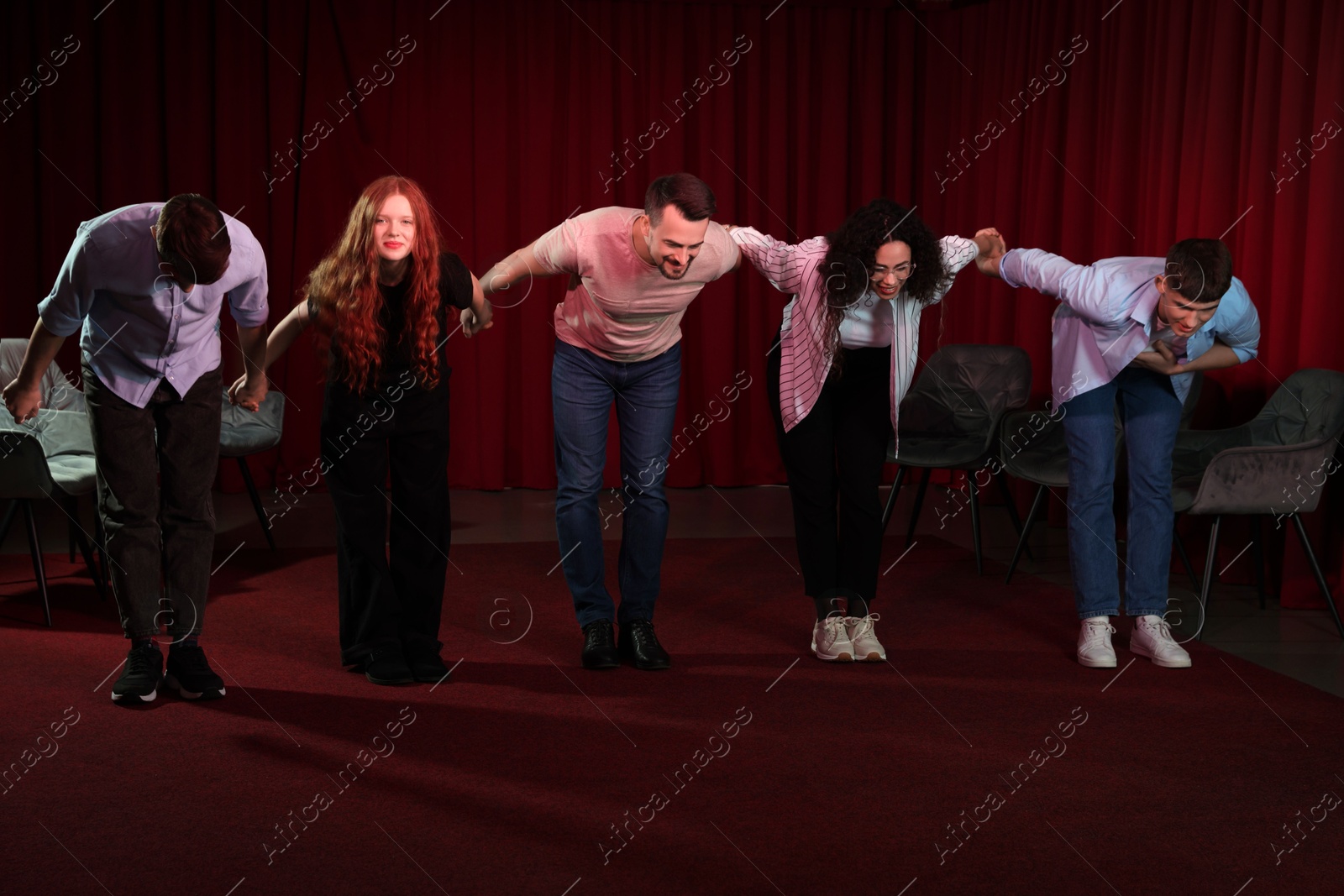 Photo of Professional actors bowing on stage in theatre