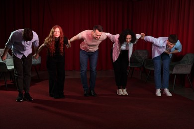 Photo of Professional actors bowing on stage in theatre