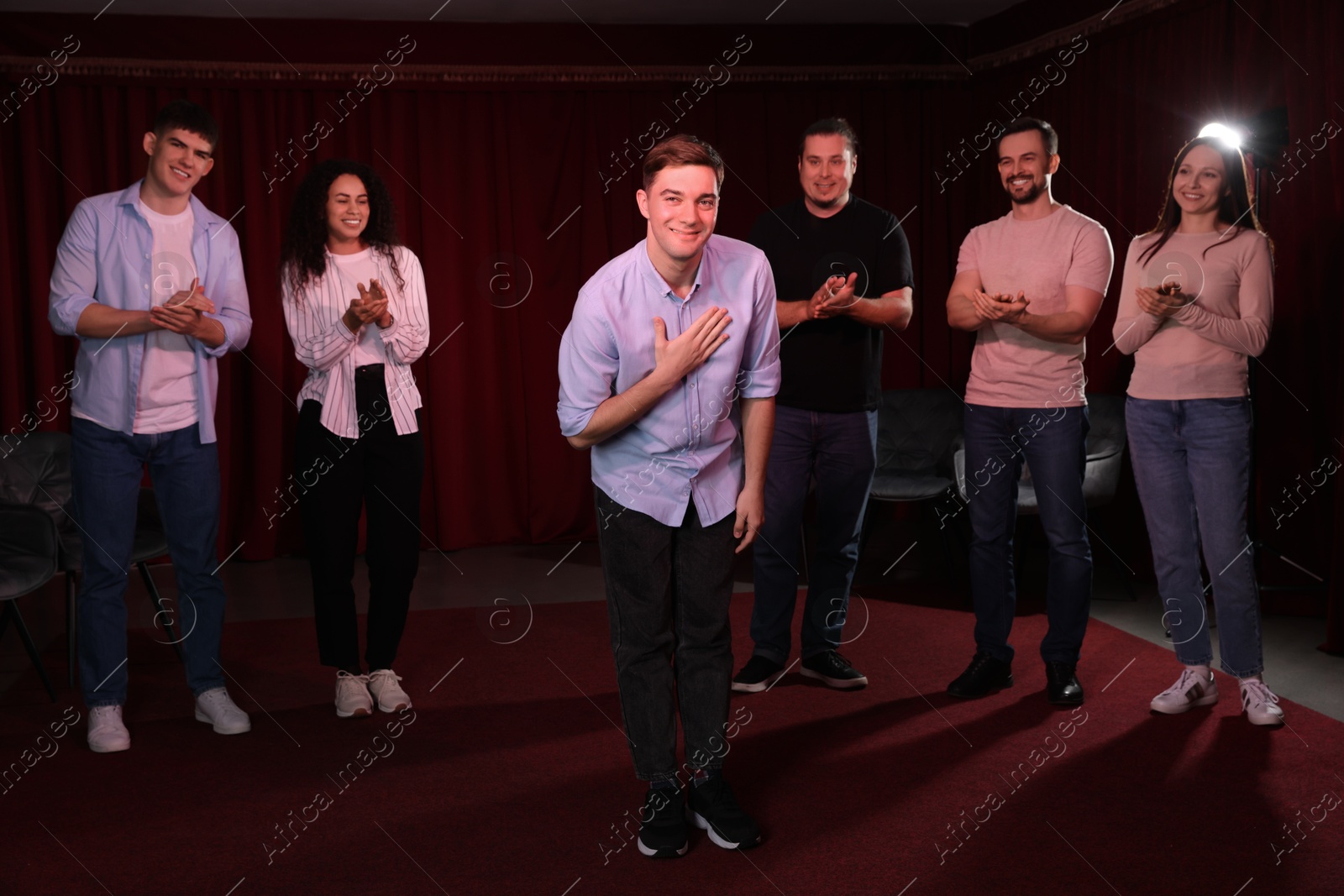 Photo of Professional actors bowing on stage in theatre