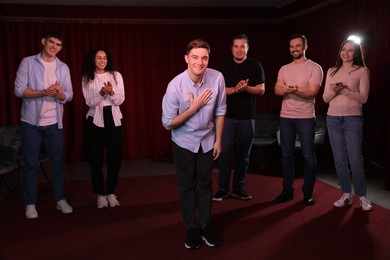 Photo of Professional actors bowing on stage in theatre