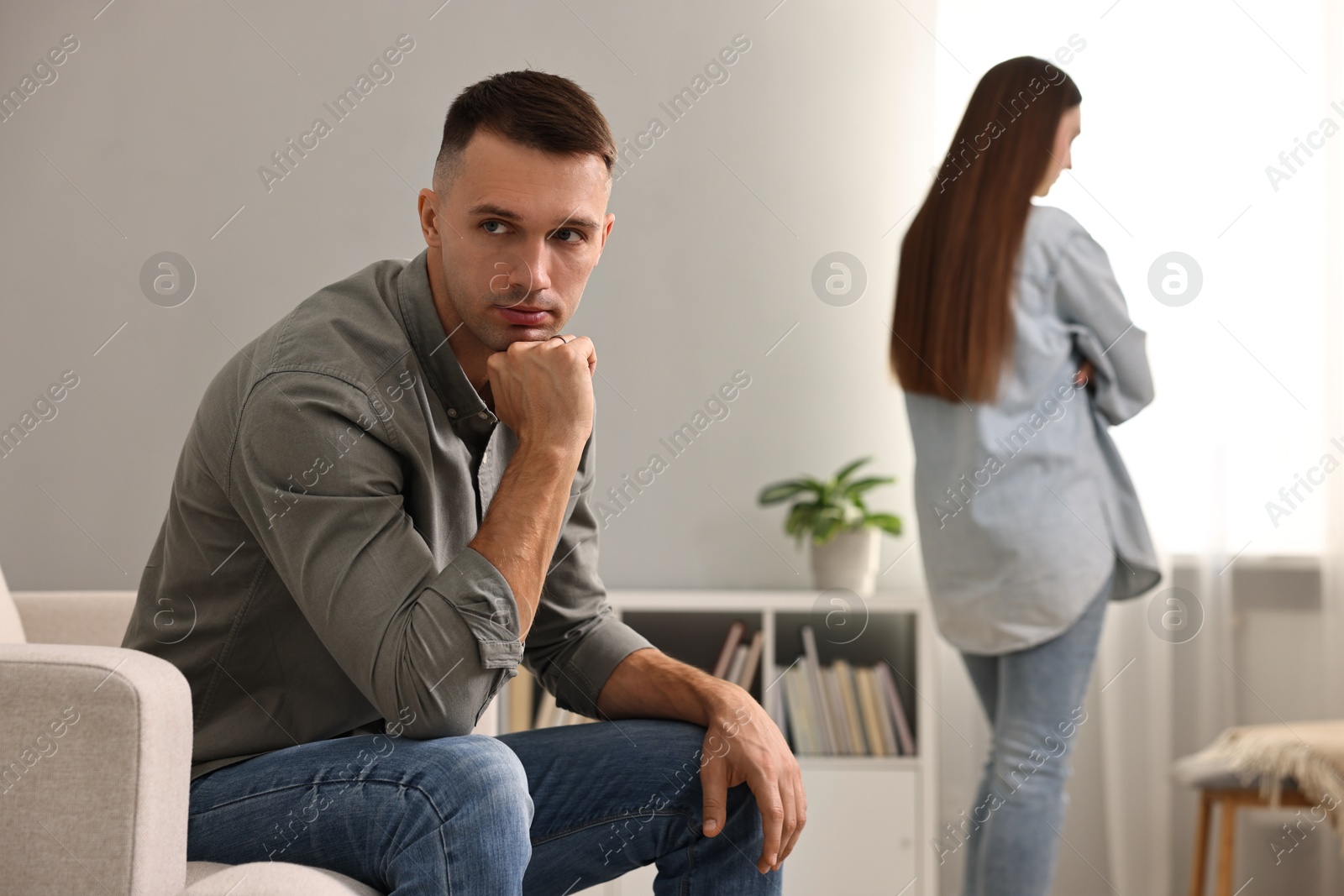 Photo of Offended couple ignoring each other at home, selective focus