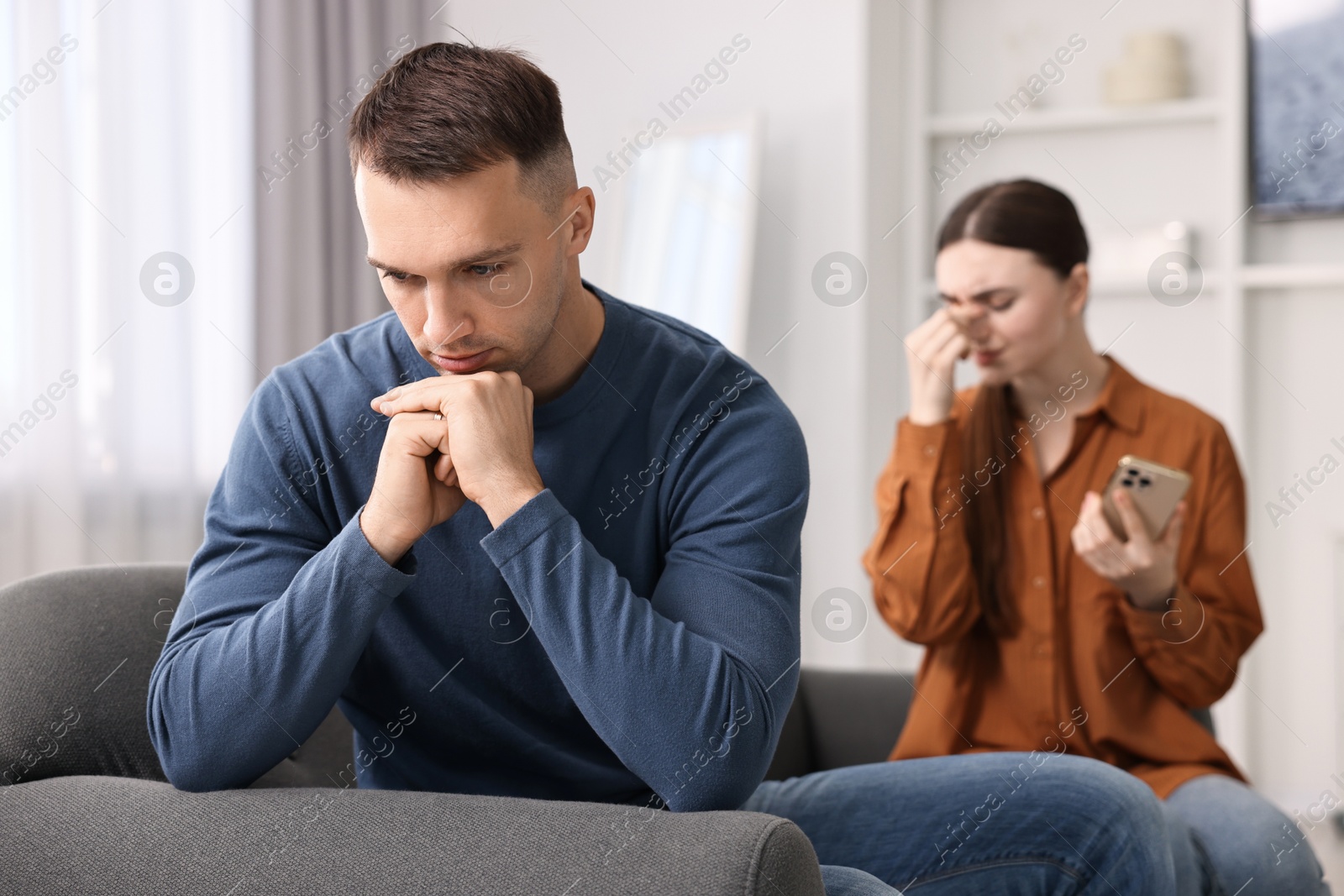 Photo of Upset couple after quarrel at home, selective focus