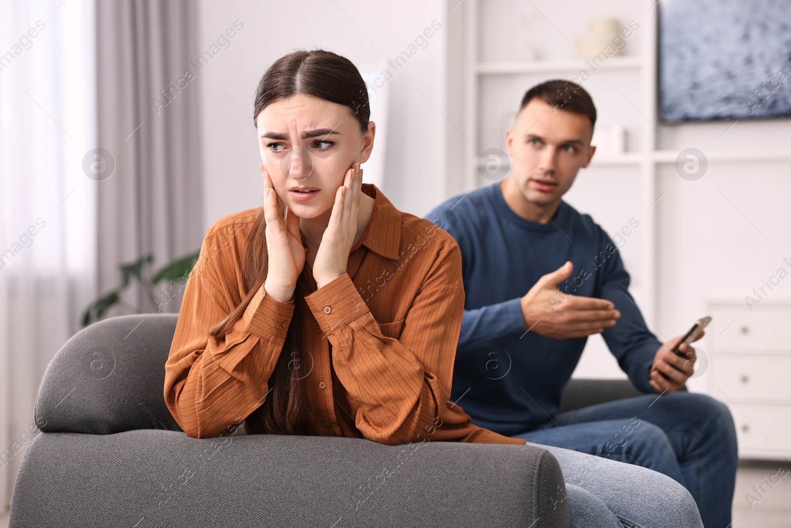 Photo of Upset woman ignoring her husband at home, selective focus