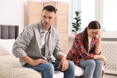 Photo of Offended couple ignoring each other at home