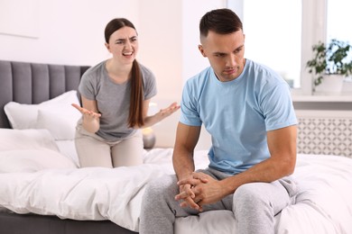 Photo of Husband ignoring his emotional wife in bedroom