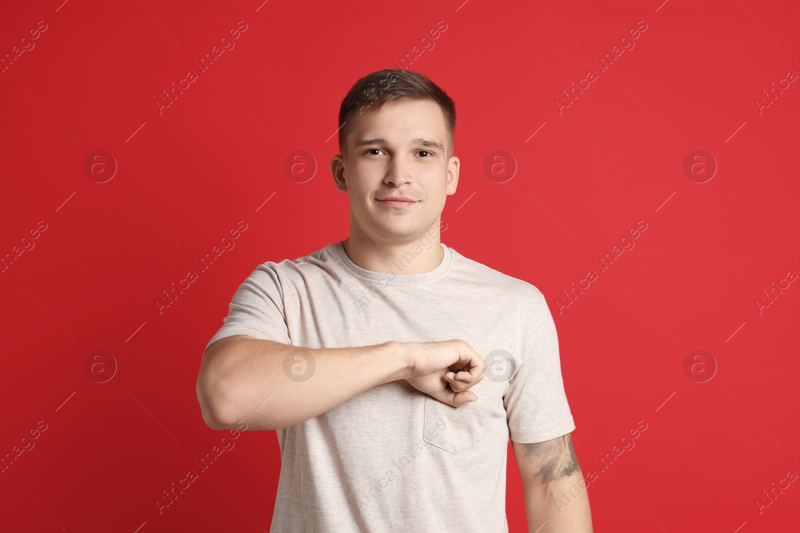 Photo of Man making promise on red background. Oath gesture