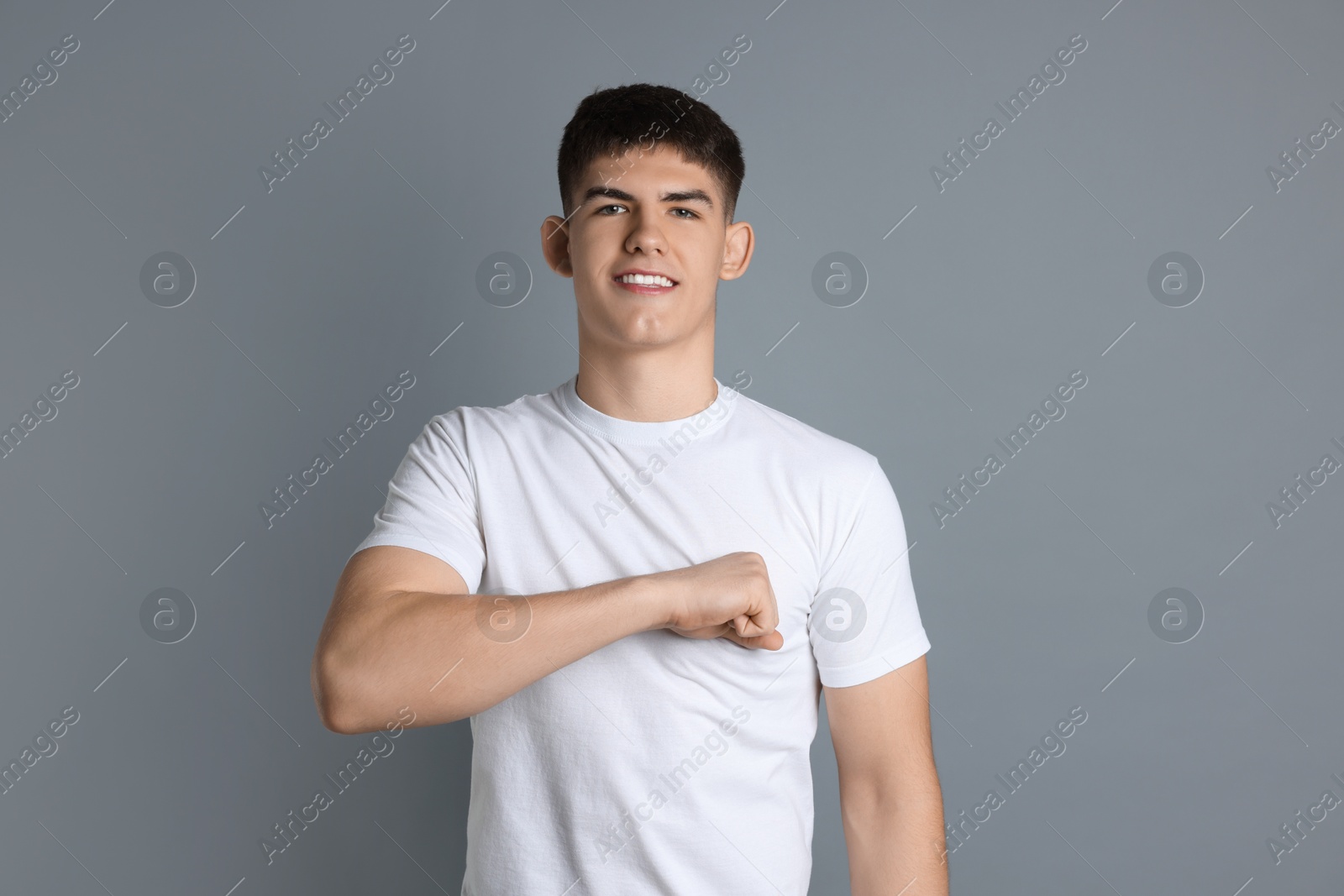 Photo of Man making promise on grey background. Oath gesture