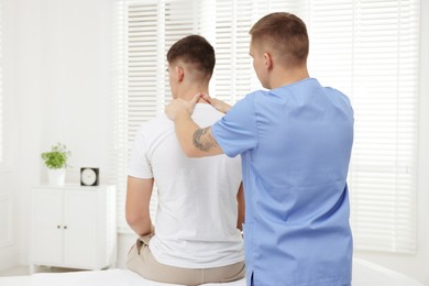 Photo of Osteopath working with patient in clinic. Manual therapy