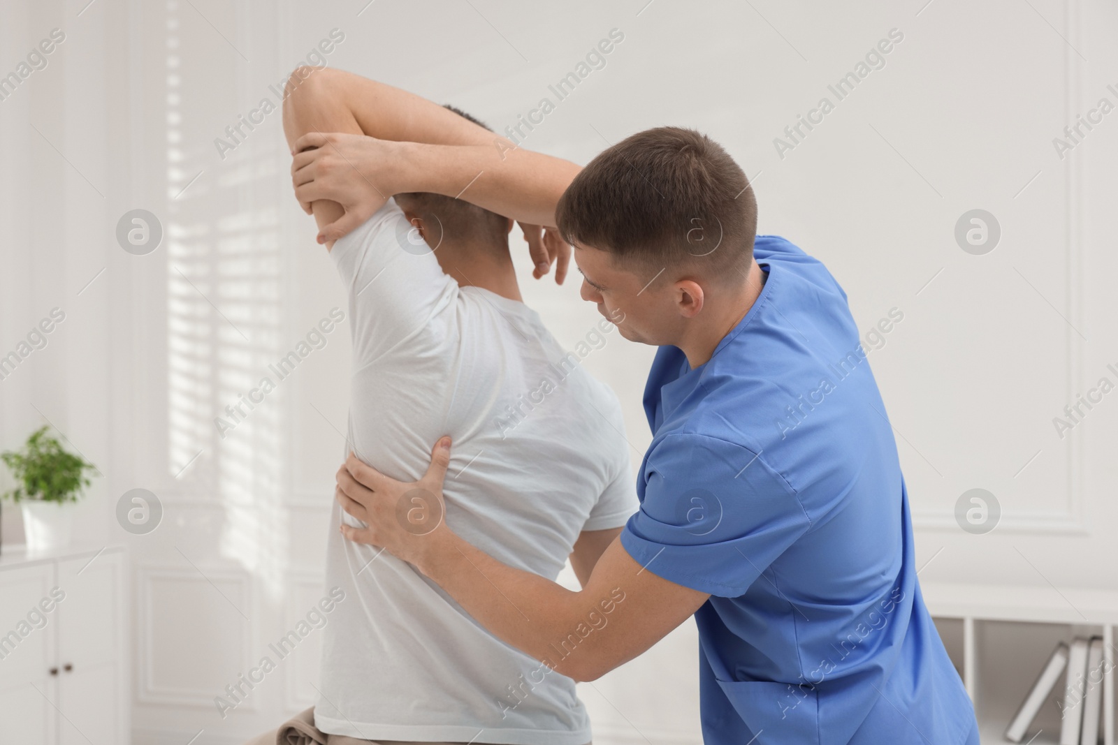 Photo of Osteopath working with patient in clinic. Manual therapy