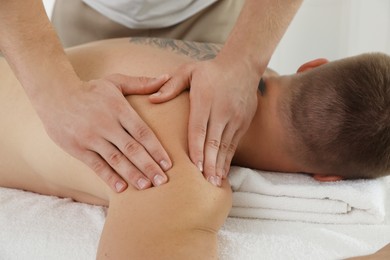 Photo of Massage therapist working with patient in clinic, closeup