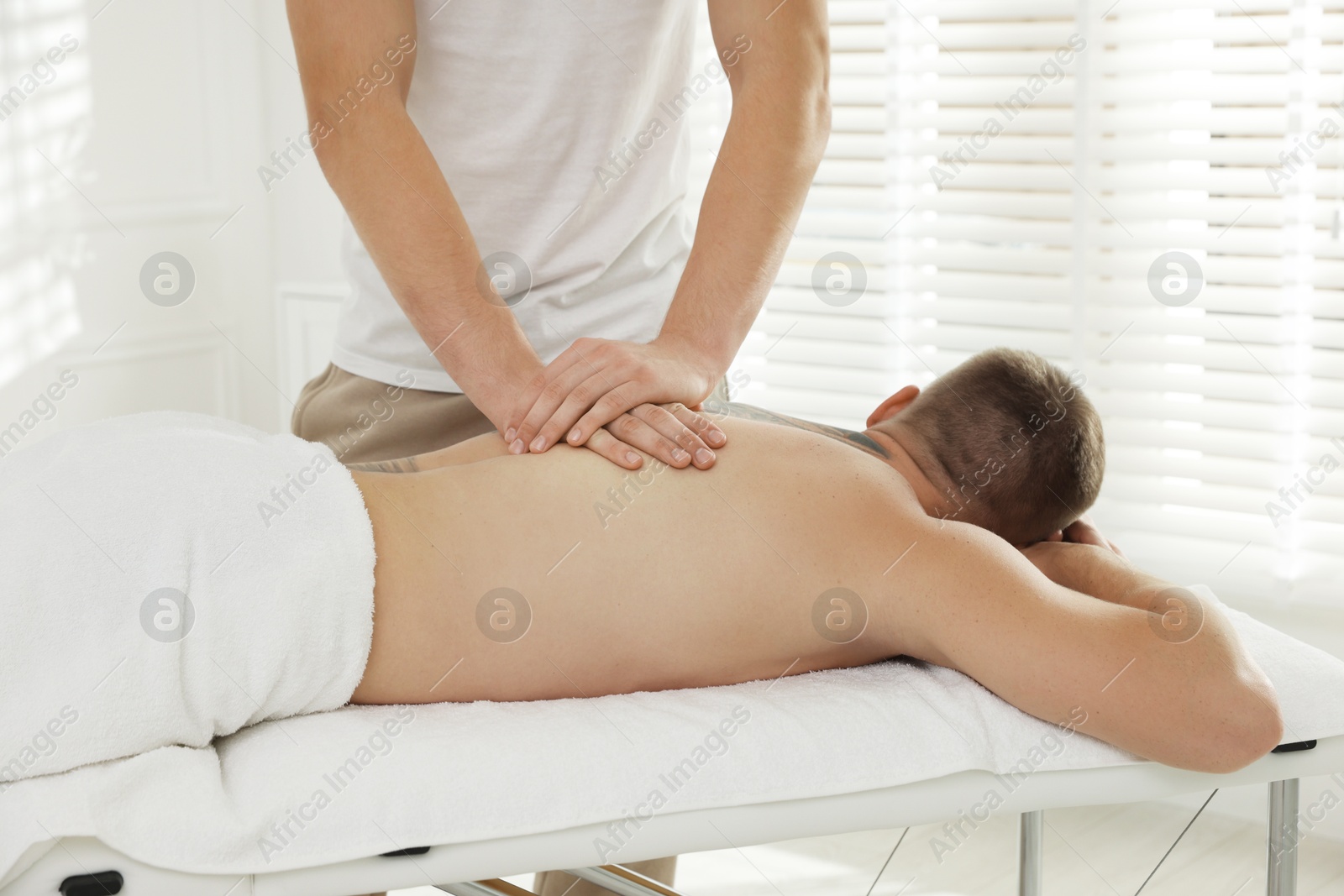 Photo of Massage therapist working with patient in clinic, closeup