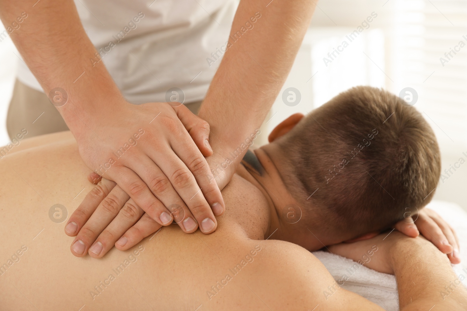 Photo of Massage therapist working with patient in clinic, closeup