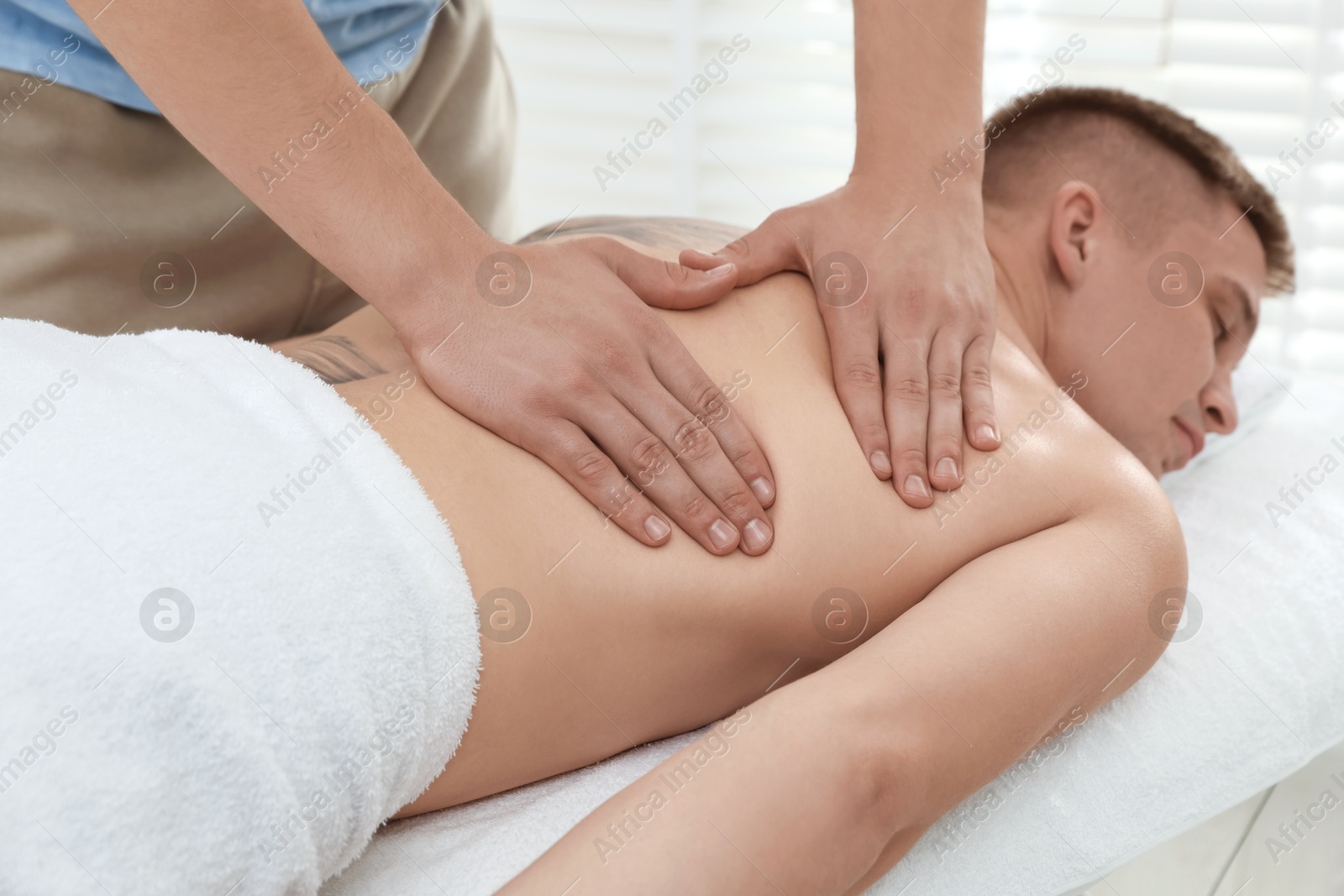 Photo of Massage therapist working with patient in clinic, closeup