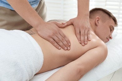 Photo of Massage therapist working with patient in clinic, closeup