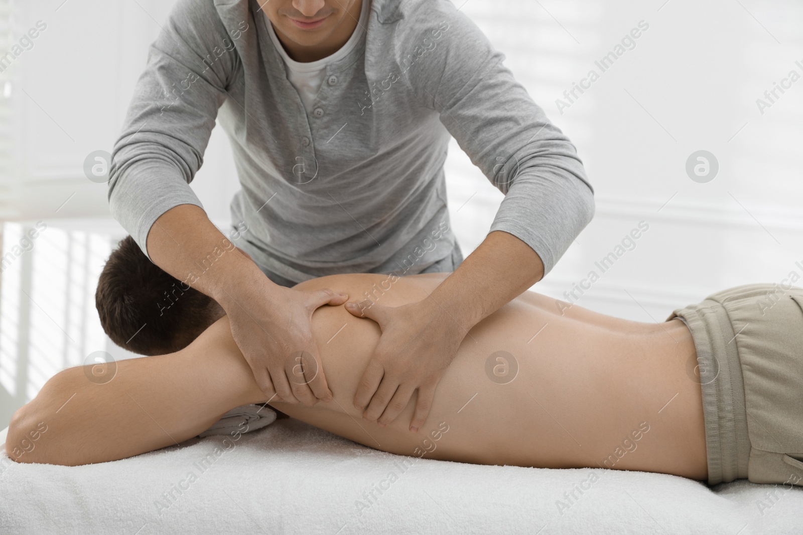 Photo of Massage therapist working with patient in clinic, closeup