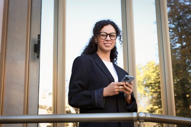 Photo of Portrait of young woman with phone wearing stylish suit outdoors