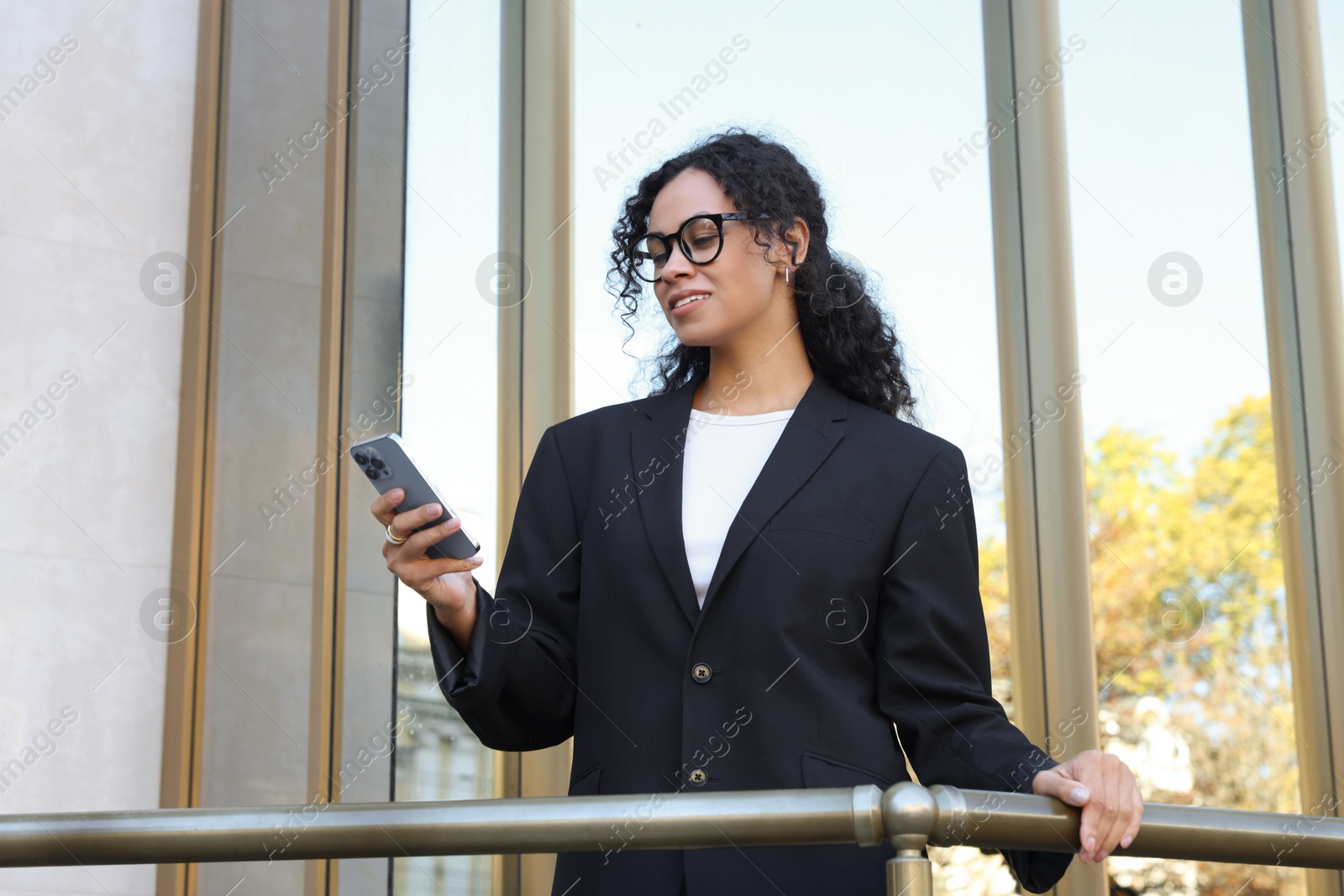 Photo of Portrait of young woman with phone wearing stylish suit outdoors