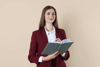 Photo of Portrait of smiling banker with book on beige background