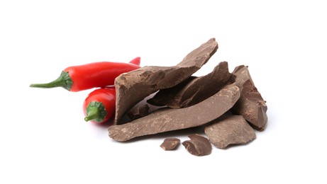 Photo of Pieces of tasty chocolate with chili peppers isolated on white