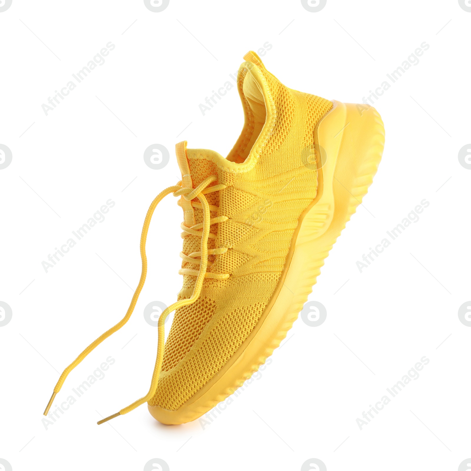 Photo of One stylish yellow sneaker isolated on white