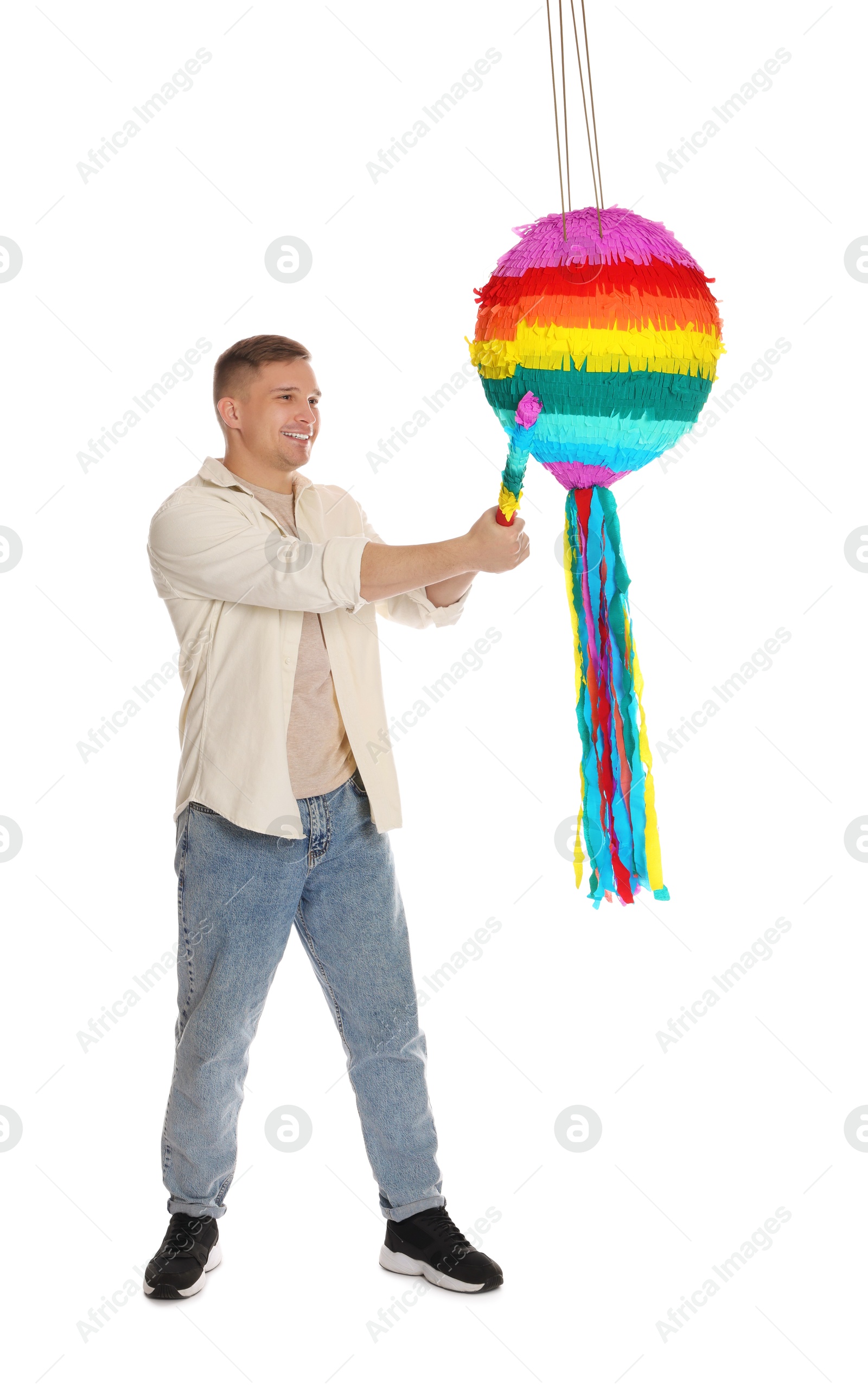 Photo of Happy man breaking pinata on white background