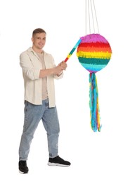 Photo of Happy man breaking pinata on white background