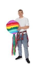 Happy man with colorful pinata on white background