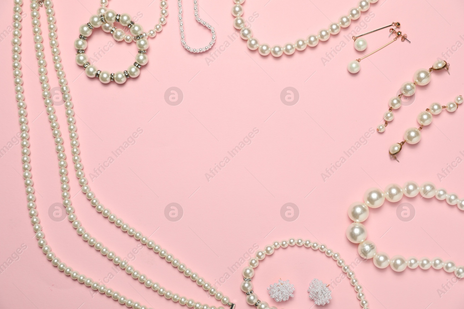 Photo of Frame made of many stylish jewelry and accessories on pink background, flat lay. Space for text