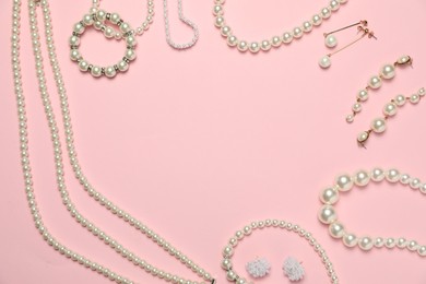 Photo of Frame made of many stylish jewelry and accessories on pink background, flat lay. Space for text